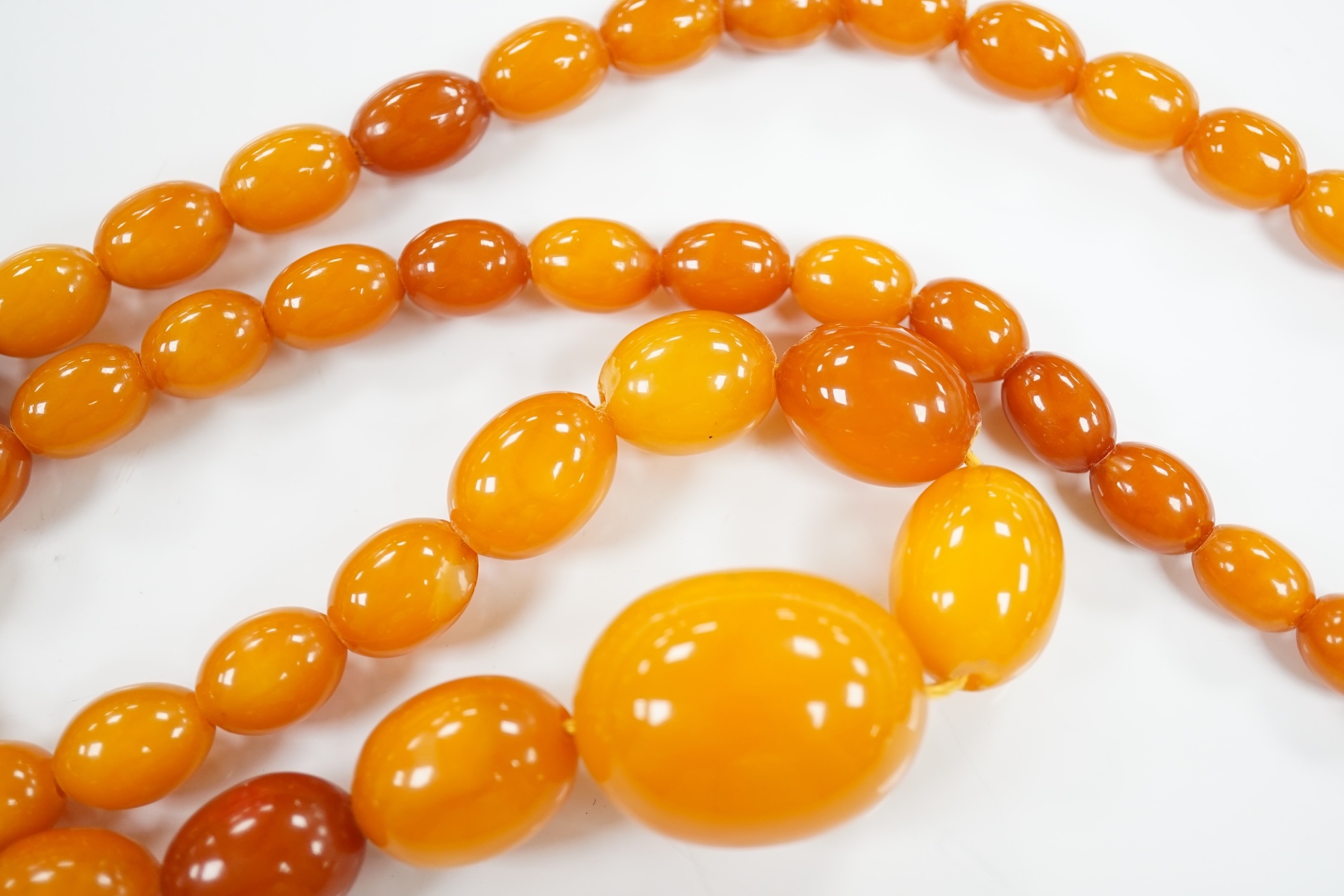 A single strand graduated oval amber bead necklace, 66cm, gross weight 48 grams. Condition - poor to fair